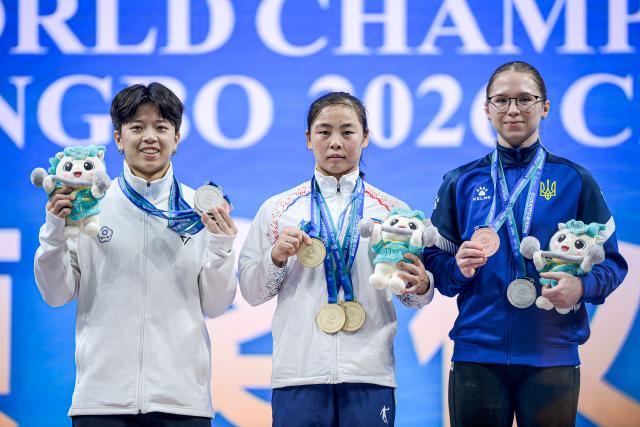 (261030) -- NINGBO, Oct. 30, 2026 (Xinhua) -- Total gold medalist Oh Kwang Ok (C) of the Democratic People's Republic of Korea (DPRK), total silver medalist Chen Guan-Ling (L) of Chinese Taipei and total bronze medalist Olha Ivzhenko of Ukraine pose for photos during the awarding ceremony of women's 57kg at the 2026 IWF World Championships in Ningbo, east China's Zhejiang Province, Oct. 30, 2026. (Xinhua/Jiang Han)