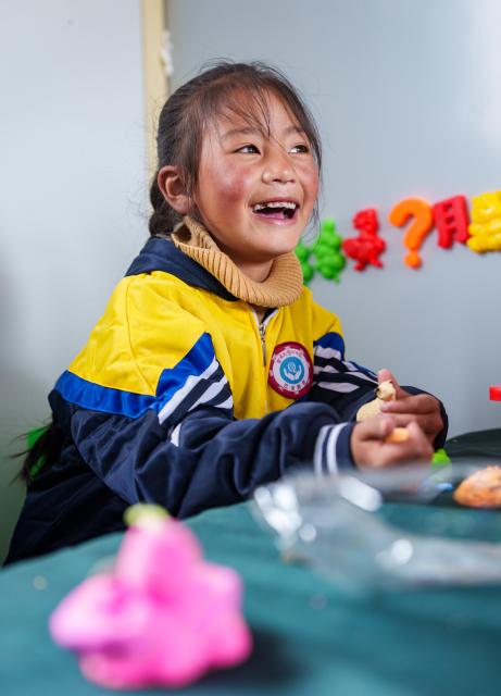 (261030) -- BAQEN, Oct. 30, 2026 (Xinhua) -- A child makes a handicraft at a makeshift kindergarten at a resettlement site of a quake-hit village in Maru Township of Baqen County, Nagqu City, southwest China's Xizang Autonomous Region, on Oct. 30, 2026. A makeshift kindergarten opened recently at a resettlement site here. Inside the comprehensively disinfected and carefully decorated facility, teachers are helping children from quake-hit villages adapt as soon as possible to learning and daily life at the resettlement site. (Xinhua/Tenzin Nyida)