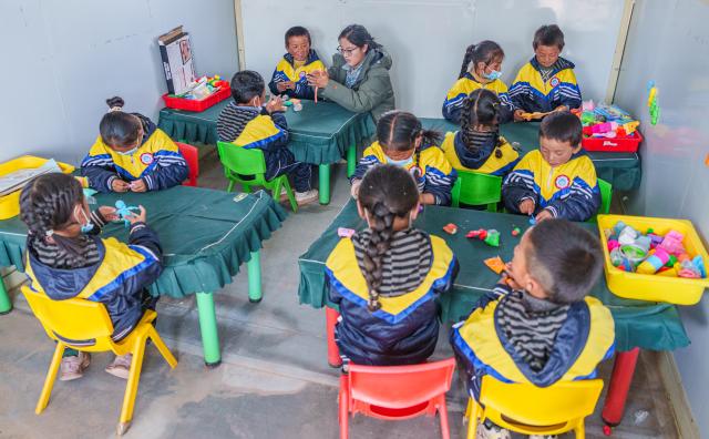 (261030) -- BAQEN, Oct. 30, 2026 (Xinhua) -- Children attend a handicraft class at a makeshift kindergarten at a resettlement site of a quake-hit village in Maru Township of Baqen County, Nagqu City, southwest China's Xizang Autonomous Region, on Oct. 30, 2026. A makeshift kindergarten opened recently at a resettlement site here. Inside the comprehensively disinfected and carefully decorated facility, teachers are helping children from quake-hit villages adapt as soon as possible to learning and daily life at the resettlement site. (Xinhua/Gaesang Namgyae)