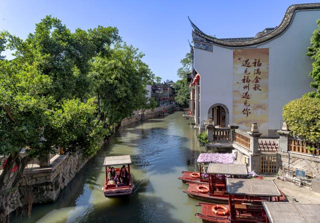 (261030) -- FUZHOU, Oct. 30, 2026 (Xinhua) -- Tourists take a boat to enjoy the scenery at the Shangxiahang traditional block in Fuzhou, southeast China's Fujian Province, Oct. 7, 2026. Fuzhou, located on the coast of the East China Sea and the banks of the Minjiang River, is a renowned historical city with a history of over 2,200 years. Relying on its natural endowments and cultural heritage, Fuzhou has coordinated urban renewal, ecological governance, cultural heritage preservation and other aspects to promote high-quality and sustainable urban development. (Xinhua/Wei Peiquan)