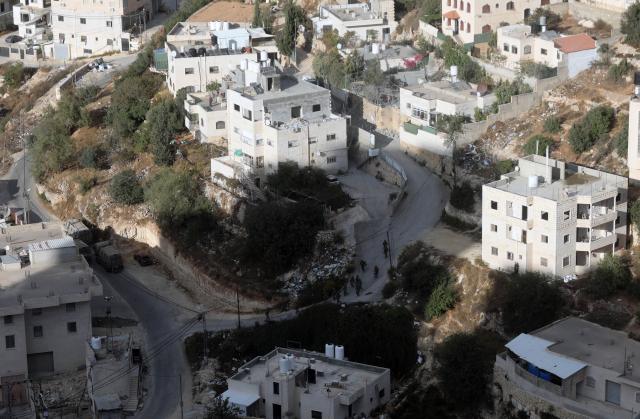 (261030) -- HEBRON, Oct. 30, 2026 (Xinhua) -- Israeli soldiers are seen before the Israeli forces blow up the homes of two Palestinians accused of killing two Israeli soldiers in the southern West Bank city of Hebron, Oct. 30, 2026. Israeli forces on Friday blew up the homes of two Palestinians accused of killing two Israeli soldiers in the southern West Bank city of Hebron, as a military operation entered its eighth day and displaced hundreds of families. (Photo by Mamoun Wazwaz/Xinhua)