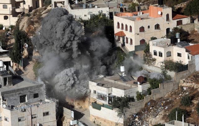 (261030) -- HEBRON, Oct. 30, 2026 (Xinhua) -- Smoke rises after Israeli forces blew up the homes of two Palestinians accused of killing two Israeli soldiers in the southern West Bank city of Hebron, Oct. 30, 2026. Israeli forces on Friday blew up the homes of two Palestinians accused of killing two Israeli soldiers in the southern West Bank city of Hebron, as a military operation entered its eighth day and displaced hundreds of families. (Photo by Mamoun Wazwaz/Xinhua)