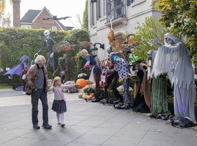 (261031) -- TORONTO, Oct. 31, 2026 (Xinhua) -- People look at Halloween decorations displayed in front of a house in Toronto, Canada, on Oct. 30, 2026. (Photo by Zou Zheng/Xinhua)