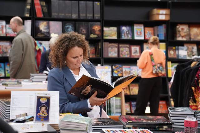(261031) -- COPENHAGEN, Oct. 31, 2026 (Xinhua) -- A visitor browses a book at Bogforum in Copenhagen, Denmark, Oct. 30, 2026. Bogforum, Denmark's largest literary festival, opened at Copenhagen's Bella Center on Friday, bringing together authors, publishers and readers for three days of book displays, talks and cultural activities. (Photo by Liu Zhichao/Xinhua)