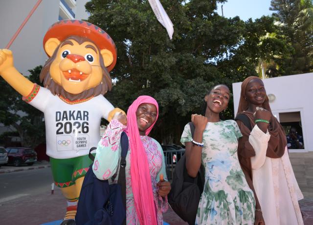 (261031) -- DAKAR, Oct. 31, 2026 (Xinhua) -- Students pose with a statue of the Youth Olympic Games official mascot Ayo ahead of the Dakar 2026 Youth Olympic Games in Dakar, Senegal, Oct. 30, 2026. (Xinhua/Yang Guang)