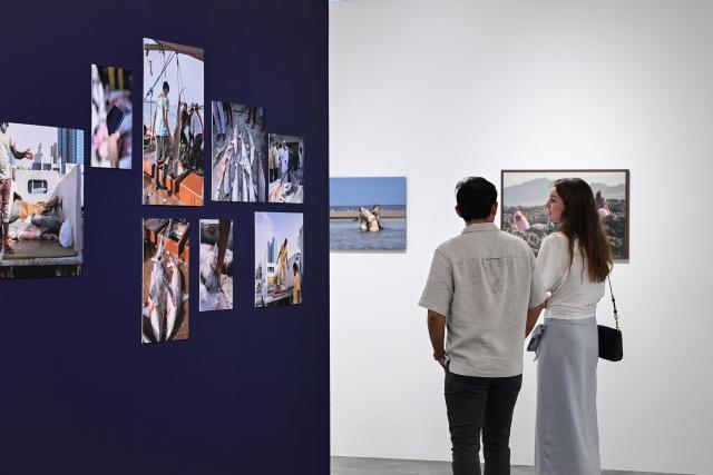 (261031) -- DUBAI, Oct. 31, 2026 (Xinhua) -- People visit a photo exhibition at Alserkal Avenue in Dubai, the United Arab Emirates, Oct. 17, 2026. Alserkal Avenue is a well-known cultural and arts hub in Dubai. In recent years, former industrial warehouses here have been transformed into a vibrant creative district through renovation and adaptive reuse. Today, it hosts contemporary art exhibitions, creative design events, cultural exchanges, and leisure activities, attracting artists, creative professionals, and visitors. (Xinhua/Wang Zecong)