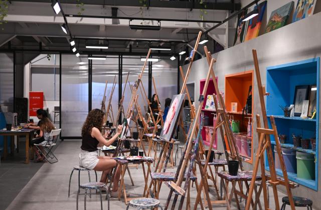 (261031) -- DUBAI, Oct. 31, 2026 (Xinhua) -- People paint at a painting studio at Alserkal Avenue in Dubai, the United Arab Emirates, Oct. 17, 2026. Alserkal Avenue is a well-known cultural and arts hub in Dubai. In recent years, former industrial warehouses here have been transformed into a vibrant creative district through renovation and adaptive reuse. Today, it hosts contemporary art exhibitions, creative design events, cultural exchanges, and leisure activities, attracting artists, creative professionals, and visitors. (Xinhua/Wang Zecong)