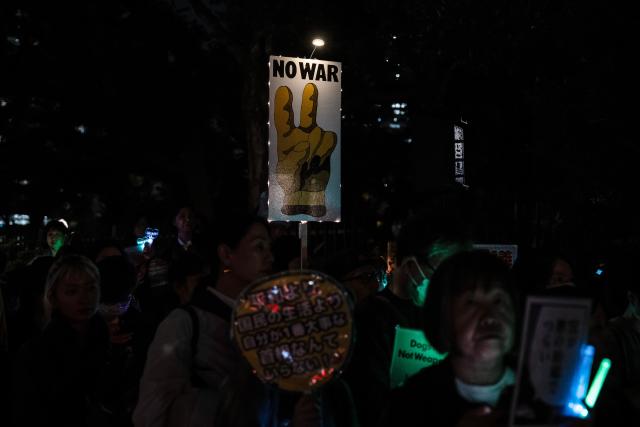 (261031) -- TOKYO, Oct. 31, 2026 (Xinhua) -- People holding signs attend a protest rally in front of the National Diet Building in Tokyo, Japan, Oct. 30, 2026. Nearly 10,000 Japanese citizens gathered in front of the National Diet Building in Tokyo on Friday evening to protest moves by Prime Minister Sanae Takaichi's government to revise the country's nuclear policy and expand its military capabilities. (Xinhua/Jia Haocheng)