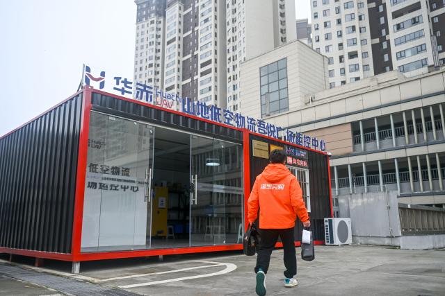 (261031) -- QINGZHEN, Oct. 31, 2026 (Xinhua) -- A deliveryman takes takeout food to a control center for low-altitude logistics service in Qingzhen City, southwest China's Guizhou Province, Oct. 30, 2026. Recently, the mountainous southwestern Chinese province of Guizhou has officially launched its first campus low-altitude drone delivery route in Qingzhen vocational education town. The aerial route connects local commercial districts directly to campuses, cutting the delivery time for teachers and students to less than 20 minutes with delivery fees starting at 3.8 yuan (about 0.57 U.S. dollars). The service also helps build a training platform integrating low-altitude industry and education to support talent cultivation. (Photo by Yuan Fuhong/Xinhua)