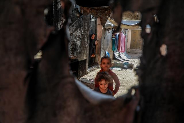 (261031) -- GAZA CITY, Oct. 31, 2026 (Xinhua) -- A Palestinian woman and her grandchildren are seen in their residence in Gaza City, Oct. 25, 2026. October 31 marks World Cities Day. In recent years, some cities across the Middle East have been battered by war. Buildings have been damaged, infrastructure destroyed, and once-bustling streets and houses have been reduced to rubble. War has not only transformed the urban landscape but also profoundly affected the daily lives of local residents. (Photo by Rizek Abdeljawad/Xinhua)