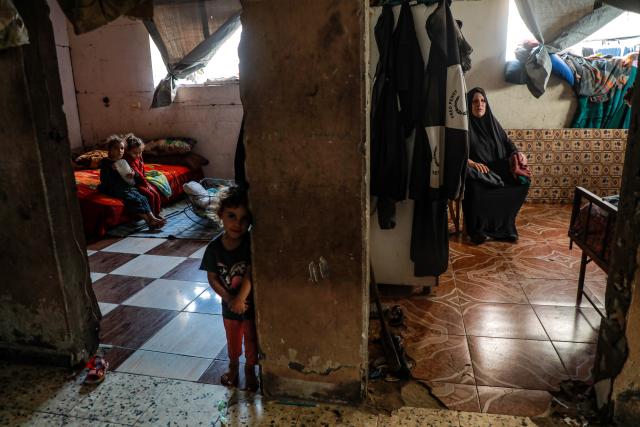 (261031) -- GAZA CITY, Oct. 31, 2026 (Xinhua) -- A Palestinian woman and her grandchildren are seen in their residence in Gaza City, Oct. 25, 2026. October 31 marks World Cities Day. In recent years, some cities across the Middle East have been battered by war. Buildings have been damaged, infrastructure destroyed, and once-bustling streets and houses have been reduced to rubble. War has not only transformed the urban landscape but also profoundly affected the daily lives of local residents. (Photo by Rizek Abdeljawad/Xinhua)