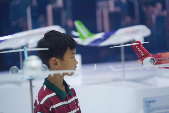 (261031) -- NANCHANG, Oct. 31, 2026 (Xinhua) -- A child views airplane models at the booth of the Commercial Aircraft Corporation of China, Ltd. at the 2026 Nanchang Aviation Industry Expo in Nanchang, east China's Jiangxi Province, Oct. 31, 2026. The expo kicked off here on Saturday, featuring dedicated exhibition areas for three major sectors including aviation manufacturing, commercial spaceflight and the low-altitude economy. The expo covers a total exhibition area of 30,000 square meters, having attracted more than 300 exhibitors. (Xinhua/Zhou Mi)