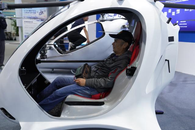 (261031) -- NANCHANG, Oct. 31, 2026 (Xinhua) -- A visitor tries an electric vertical take-off and landing aircraft at the 2026 Nanchang Aviation Industry Expo in Nanchang, east China's Jiangxi Province, Oct. 31, 2026. The expo kicked off here on Saturday, featuring dedicated exhibition areas for three major sectors including aviation manufacturing, commercial spaceflight and the low-altitude economy. The expo covers a total exhibition area of 30,000 square meters, having attracted more than 300 exhibitors. (Xinhua/Zhou Mi)