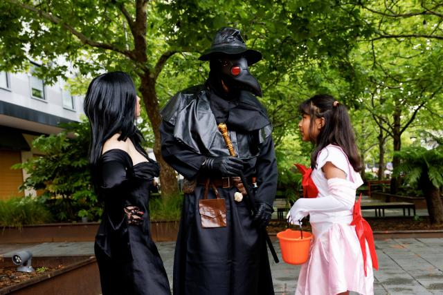 (261031) -- CANBERRA, Oct. 31, 2026 (Xinhua) -- Family members dressed in Halloween costumes interact with each other in Canberra, Australia, on Oct. 31, 2026. (Photo by Chu Chen/Xinhua)