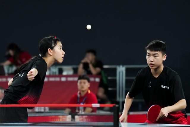 (261031) -- DIAMNIADIO, Oct. 31, 2026 (Xinhua) -- August Xiao/Han Anzhuo (L) of New Zealand compete during the mixed doubles round of 16 match of table tennis against Li Hechen/Yao Ruixuan of China at the Dakar 2026 Youth Olympic Games in Diamniadio, Senegal, Oct. 31, 2026. (Xinhua/Na Yuqi)