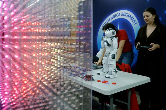 (261031) -- BUCHAREST, Oct. 31, 2026 (Xinhua) -- A participant controls her humanoid robot during the 5th edition of Robofest, a technology event, at the Polytechnic University in Bucharest, Romania, Oct. 31, 2026. The three-day festival dedicated to science, technology and robots includes, among other events, a Robochallenge contest. (Photo by Cristian Cristel/Xinhua)